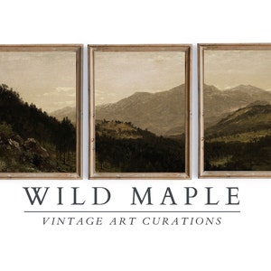 May include: A set of three framed landscape paintings depicting a mountain range with a forest in the foreground. The paintings are in a muted brown and green color palette. The text "WILD MAPLE VINTAGE ART CURATIONS" is below the paintings.