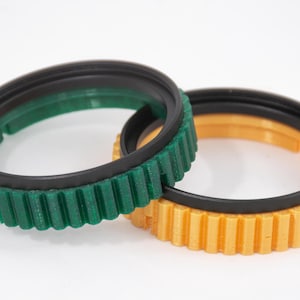 May include: Two camera lens filters, one green and one yellow, with black rubber rings.