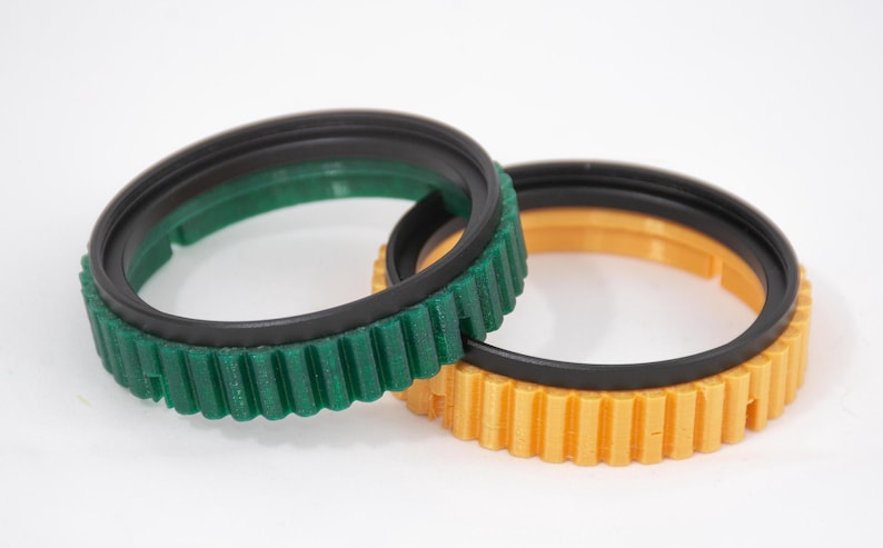 May include: Two camera lens filters, one green and one yellow, with black rubber rings.
