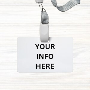 May include: A white plastic badge holder with a gray lanyard. The badge holder has the text "YOUR INFO HERE" printed on it.
