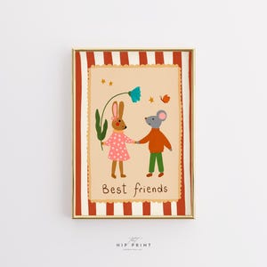 Op de afbeelding: Een ingelijste print met een grillige illustratie van een konijn en een muis die elkaars hand vasthouden. Het konijn draagt een roze jurk en de muis draagt een oranje shirt en een groene broek. De tekst "Best friends" staat onderaan.