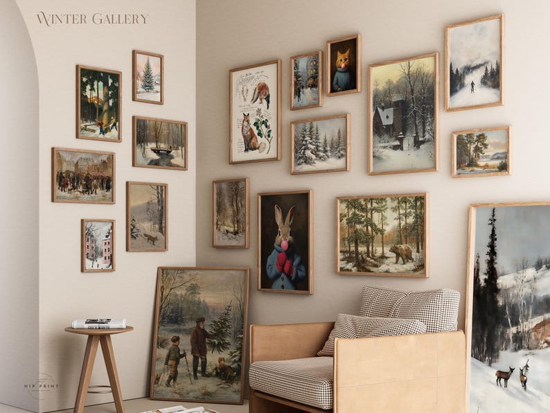 May include: A gallery wall with a winter theme featuring various framed prints. The prints include images of animals, landscapes, and scenes of winter activities. The wall is painted a light beige colour and the frames are all in a similar style. The text "WINTER GALLERY" is displayed at the top of the wall.