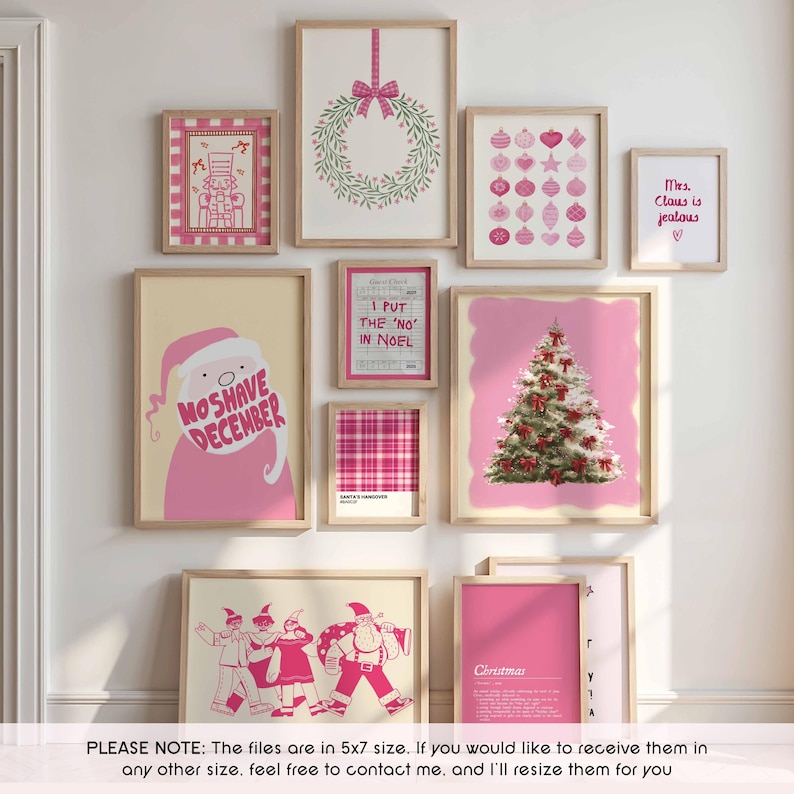 May include: A collection of framed Christmas-themed art prints in pink and beige. The prints feature a wreath, ornaments, a Christmas tree, Santa Claus, and text that reads "No Shave December" and "Mrs. Claus is jealous."