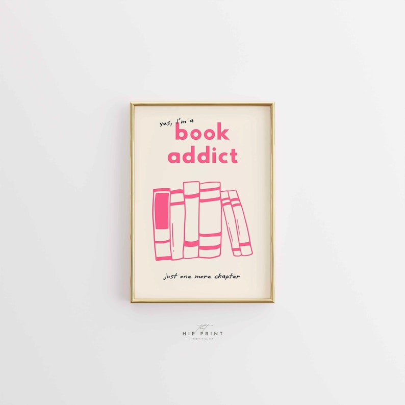 May include: A framed print with a gold border. The print features the text "yes, I'm a book addict" in pink, above a pink illustration of a stack of books. Below the books is the text "just one more chapter".