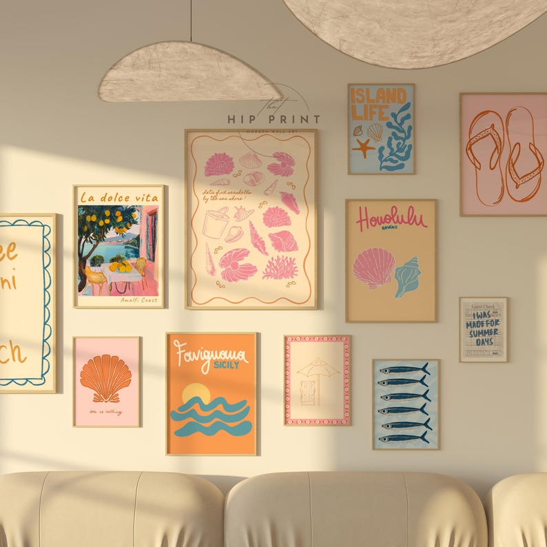 May include: A wall gallery featuring a collection of 10 framed prints with a summery theme. The prints feature illustrations of seashells, fish, a beach umbrella, a lemon tree, and the text "Island Life", "Honolulu", "Favignana Sicily", "La dolce vita", and "Twas made for summer days".