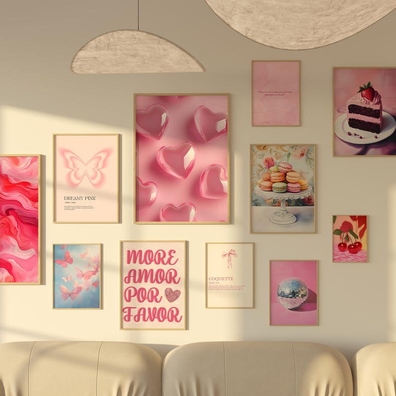 May include: A gallery wall with a variety of framed prints, including a pink butterfly, a pink heart design, a pink cake, a pink macaron tower, a pink disco ball, and a pink quote print. The wall is painted a light beige color.