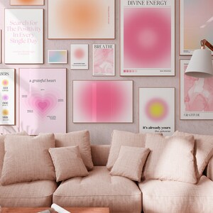 Pode incluir: Um interior de sala de estar com um sof&aacute; rosa claro e v&aacute;rias impress&otilde;es emolduradas na parede. As impress&otilde;es apresentam gradientes rosa e amarelo, formas abstratas e cita&ccedil;&otilde;es inspiradoras como "Procure a positividade em cada dia", "um cora&ccedil;&atilde;o grato", "RESPIRE", "ENERGIA DIVINA", "j&aacute; &eacute; seu - o universo", e "GRATID&Atilde;O".