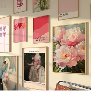 May include: A gallery wall with various framed prints, including a pink peony floral print, a print with the text "This Has Place", a print with the text "Pink Peony", a print with the text "Neoclassicism", a print with the text "bo pulser les vagues, a mar, on plonge", a print with a swan, a print with hearts, and a print with macarons.