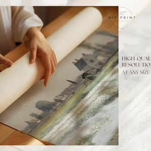 May include: A person is rolling up a canvas print of a painting depicting a landscape with a village in the distance. The print is on a white background and has a light brown wooden frame. The text "HIGH QUALITY RESOLUTION AT ANY SIZE" is visible in the lower right corner of the image.
