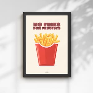 Könnte beinhalten: Ein gerahmter Kunstdruck mit einer roten Schachtel voller goldgelber Pommes frites vor einem cremefarbenen Hintergrund. Der Text NO FRIES FOR FASCISTS ist in fetten, braunen Großbuchstaben über den Pommes in einer serifenlosen Schrift.