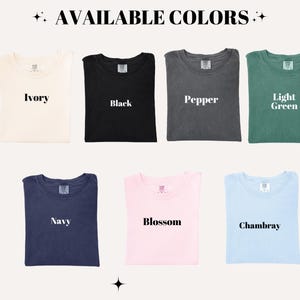 Puede incluir: Imagen que muestra una selecci&oacute;n de camisetas en varios colores. Los colores disponibles son marfil, negro, pimienta, verde claro, azul marino, flor y chambray. Cada camiseta est&aacute; cuidadosamente doblada y etiquetada con su nombre de color.