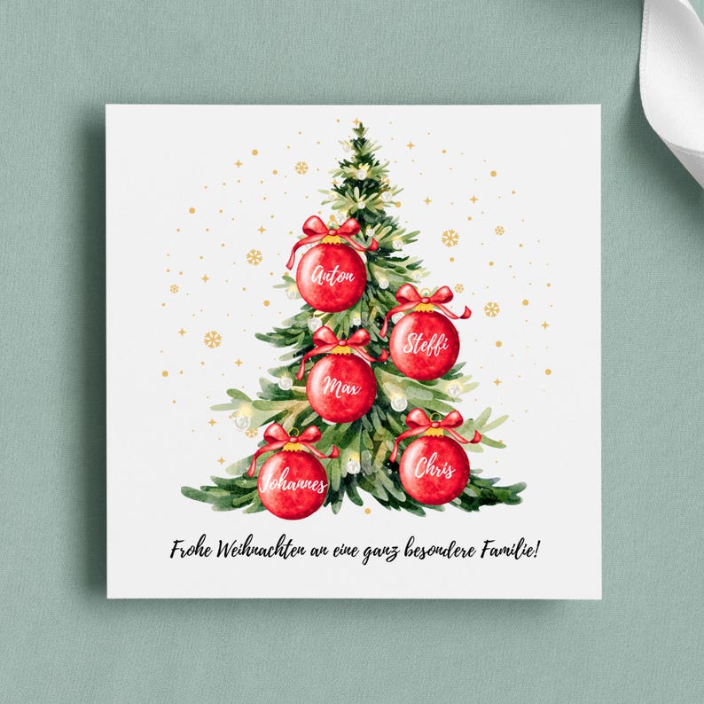 May include: A Christmas card featuring a watercolor illustration of a Christmas tree adorned with red ornaments, each bearing a name. The card includes the text "Frohe Weihnachten an eine ganz besondere Familie!" and gold snowflakes.