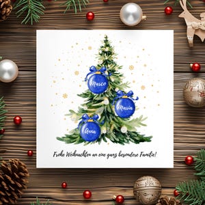 May include: A Christmas card featuring a watercolor illustration of a Christmas tree adorned with blue ornaments. Each ornament has a name on it. The card has the text "Frohe Weihnachten an eine ganz besondere Familie!"