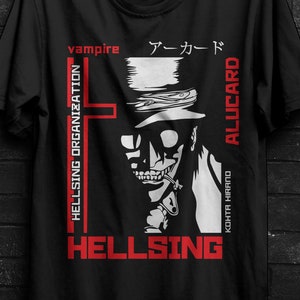 Può includere: T-shirt nera con una grafica di un personaggio con cappello e sigaretta, con la scritta "HELLSING" e "ALUCARD". La maglietta include anche testo giapponese e le parole "HELLSING ORGANIZATION".