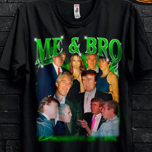 May include: Black t-shirt featuring a group of people and the text "ME & BRO" in green. The shirt has promotional text and a butterfly decoration. The t-shirt is hanging on a black hanger.