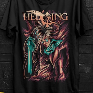 Puede incluir: Camiseta negra con un diseño gráfico detallado de la serie de anime Hellsing. El diseño presenta un personaje con pelo largo, gafas y una pistola, con la palabra "HELLSING" encima. La camiseta está colgada.