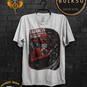 May include: White t-shirt featuring a graphic of a character in a red suit and hat, surrounded by black tentacles and red eyes. The text "DARKNESS IS FULL OF MYSTERIES & SURPRISES" is displayed on the shirt.