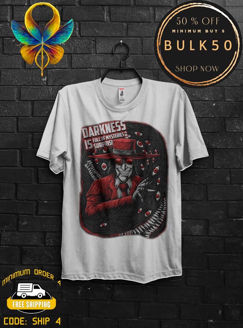 May include: White t-shirt featuring a graphic of a character in a red suit and hat, surrounded by black tentacles and red eyes. The text "DARKNESS IS FULL OF MYSTERIES & SURPRISES" is displayed on the shirt.