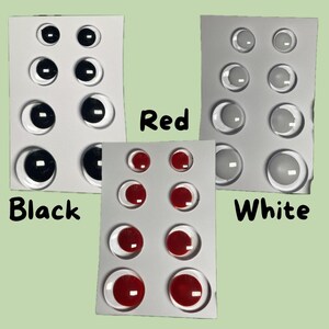 K&ouml;nnte beinhalten: Drei S&auml;tze Bastelaugen in Schwarz, Rot und Wei&szlig;. Jeder Satz ist auf einer wei&szlig;en Karte angeordnet. Die schwarzen Augen haben schwarze Pupillen, die roten Augen haben rote Pupillen und die wei&szlig;en Augen haben klare Pupillen. Die W&ouml;rter "Black", "Red" und "White" sind auf dem Bild geschrieben.