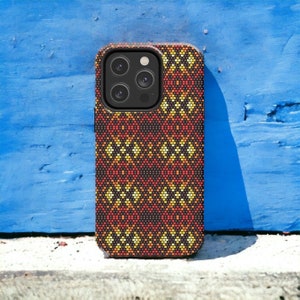 Puede incluir: Una funda de teléfono negra con un patrón geométrico en tonos naranja, amarillo y rojo. La funda tiene un recorte para el objetivo de la cámara.