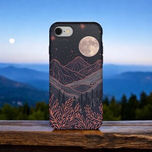 Könnte beinhalten: Eine schwarze Handyhülle mit einem Motiv einer Bergkette unter einem Vollmond und Sternen. Die Berge sind in Pink umrandet und der Himmel ist dunkelblau.