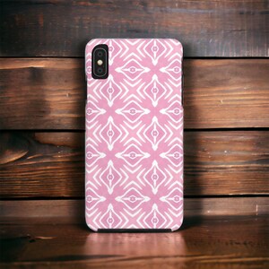 May include: A pink phone case with a white geometric pattern. The case has a cutout for the camera lens.