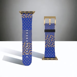 May include: A blue and gold patterned Apple Watch band with a gold buckle. The band has a geometric pattern with leaves and arrows.