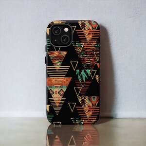 Puede incluir: Una funda de teléfono negra con un patrón geométrico de triángulos en tonos naranja, rojo, azul y verde. Los triángulos están rellenos de diferentes patrones, incluyendo rayas, zigzags y diamantes.