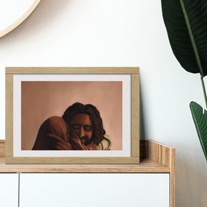 May include: A framed illustration of two people embracing. The background is a soft peach color. The people are depicted with dark skin and hair. The man has a beard and is wearing a light brown garment. The woman is wearing a dark brown garment.