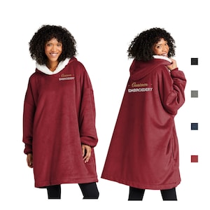 Pu&ograve; includere: Una felpa con cappuccio oversize bordeaux con cappuccio foderato in sherpa bianco. Il testo ricamato "Custom EMBROIDERY" &egrave; presente sulla parte anteriore e posteriore. L'immagine mostra la felpa con cappuccio da davanti e da dietro, con campioni di colore.