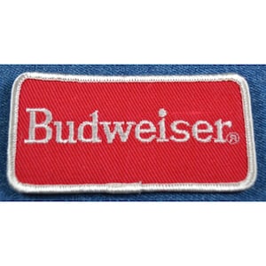 May include: Red embroidered patch with white text that reads "Budweiser" with a registered trademark symbol.