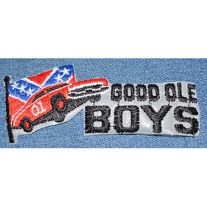 May include: A white patch with black embroidered text that reads "GOOD OLE BOYS" and a red, white, and blue embroidered flag with a red car driving over it.