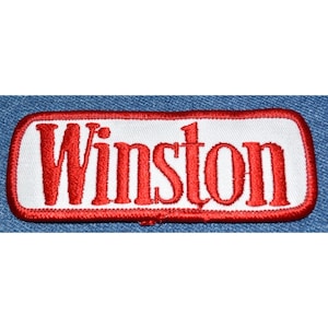 May include: Red embroidered patch with the word "Winston" in white lettering on a white background.