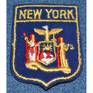 May include: A blue and gold embroidered patch with the words "NEW YORK" and the New York City seal.