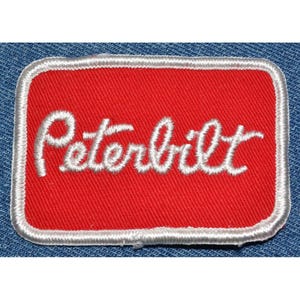 May include: Red embroidered patch with a white "Peterbilt" logo.