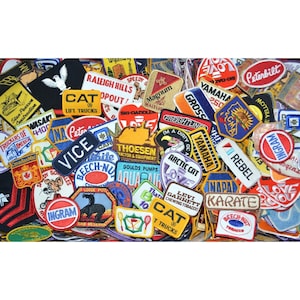 May include: A collection of colorful embroidered patches featuring various logos and designs, including brands like Caterpillar, Yamaha, and Levi Garrett. The patches are made of different materials and feature a variety of colors, including red, blue, yellow, and green.