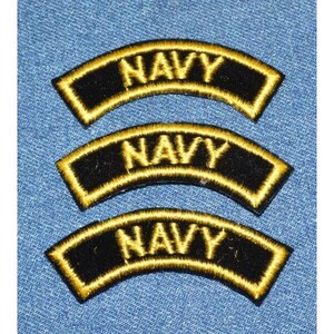 May include: Three black and yellow embroidered patches with the word "NAVY" in yellow lettering.
