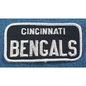 May include: Black and white embroidered patch with the text "Cincinnati Bengals" in white.