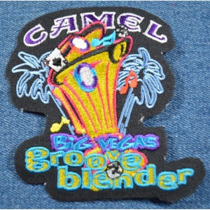 May include: A black embroidered patch with a yellow, pink, and blue cartoon image of a jukebox with palm trees and the text "CAMEL Big Vegas Groove Blender".