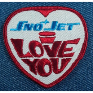 May include: Red and white heart-shaped embroidered patch with the text "Sno-Jet Love You" in red and blue lettering.