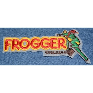 May include: Embroidered patch featuring the word "FROOGER" in red and yellow, with a green frog character carrying a briefcase. The patch includes the text "©1981 SEGA".