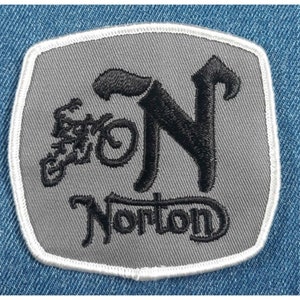 May include: A gray embroidered patch with a black motorcycle and the text "Norton" in a stylized font.