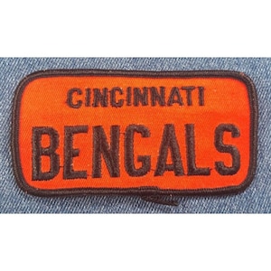 May include: A red and black embroidered patch with the text "Cincinnati Bengals" in black lettering.