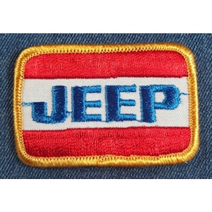May include: A red, white, and blue embroidered patch with the word "JEEP" in blue lettering.