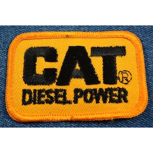 May include: Yellow and black embroidered patch with the text "CAT DIESEL POWER" and a registered trademark symbol.