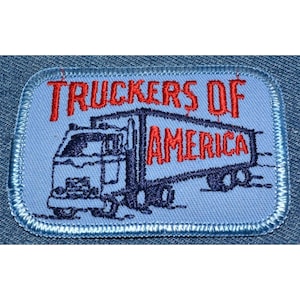 May include: A blue and red embroidered patch with a semi-truck and the text "Truckers of America".