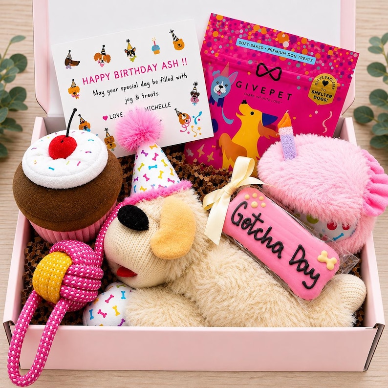 May include: A pink gift box containing a plush cupcake toy, a plush dog toy wearing a party hat, a pink rope toy, a bag of GivePet dog treats, a plush pink cake toy with a candle, and a rectangular cookie with the text Gotcha Day.
