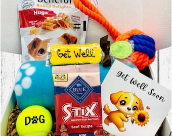 Op de afbeelding: Een cadeaupakket voor honden met lekkernijen, een touwspeeltje, een tennisbal en een kaart met de tekst "Get Well Soon". De doos bevat een blauw pluche speelgoed en een gele botvormige traktatie met "Get Well" erop.