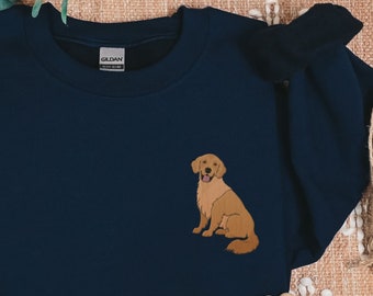 May include: A navy blue sweatshirt with a golden retriever dog embroidered on the front. The dog is sitting with its tongue out and looking to the right.
