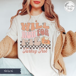 May include: White t-shirt with a retro design that says "Will Run For Pie" with a cute pie graphic and "Turkey Trot" underneath.